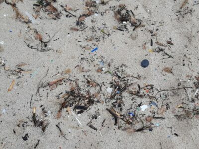 Kleiner Plastikmüll im Sand der Cala Agulla